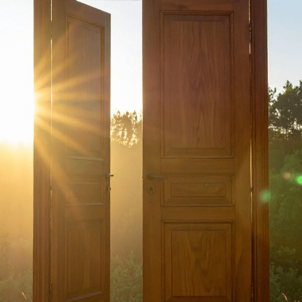Open wooden door with warm sunlight streaming through, a metaphor for psychological safety at work