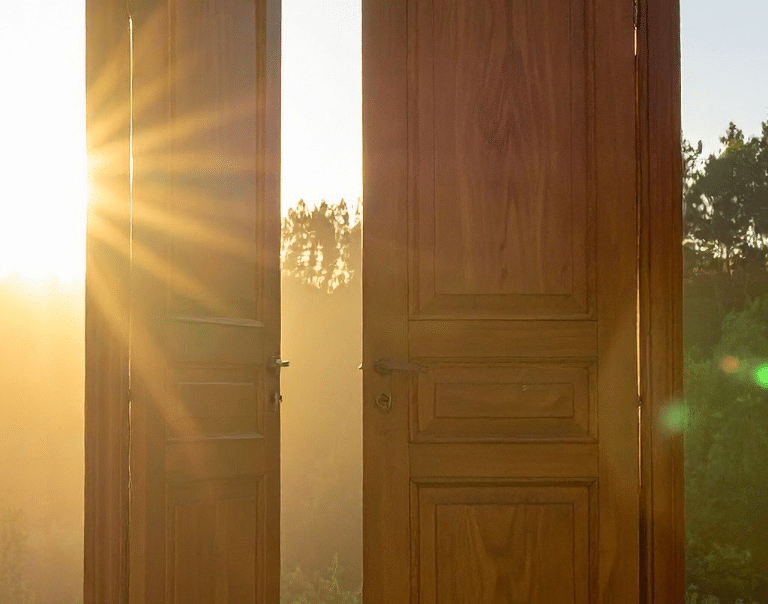 Open wooden door with warm sunlight streaming through, a metaphor for psychological safety at work