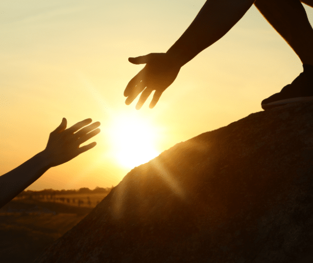 What is leadership: a mentor's hand guiding, reaching toward warm light